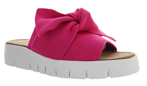The Bernie Mev Freesia in fuchsia stretch fabric is a stylish slide with a twisted bow adornment.