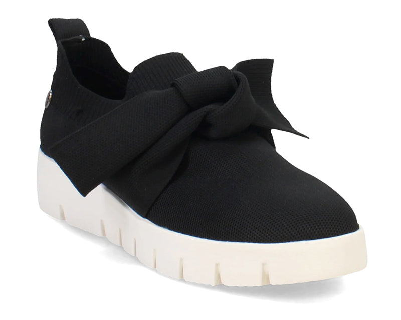 The FX Serenity in black stretch fabric is an adorable sneaker with a twisted bow.