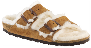 The popular BIRKENSTOCK Arizona is a classic model with two adjustable straps. Featured in genuine high-quality suede – and is now available in an extra cozy version thanks to a soft, bright genuine shearling lining on the anatomically formed cork-latex footbed and straps. These sandals are perfect for chilly, winter evenings.
