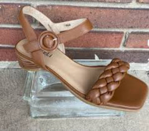 The Kalee is a braided-strap leather sandal with a squared toe. Featuring a circular leather covered adjustable buckle with hidden elastic insert. Padded leather insole. Heel height approximately 1.25 inch sculptural wood heel.