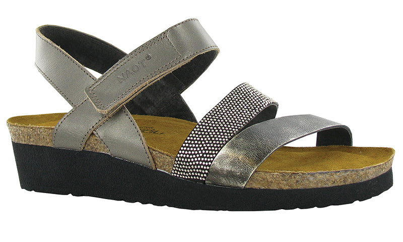 The Krista is a three strap sandal with a hook and loop strap at the instep and a backstrap for added stability and support. The Krista has gore at the middle strap for adjustability.  This style features a studded strap to give it a dressier look.    Naot's anatomic cork and latex footbed is wrapped in pampering suede and molds to the shape of the foot with wear.  Heel height is approximately 1 inch.